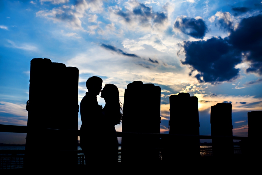 A silhouette of an engaged couple hugging on the river walk along the hudson in manhattan during their engagement session.